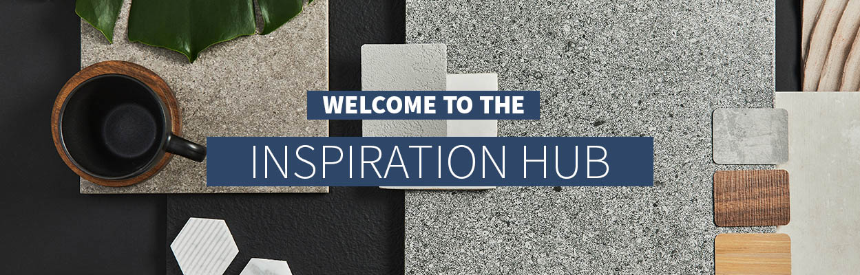 Amy wilson working on a laptop in front of grey taped wooden blinds