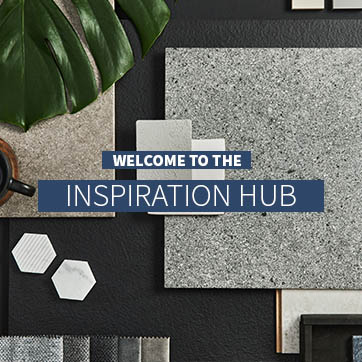 Amy wilson working on a laptop in front of grey taped wooden blinds