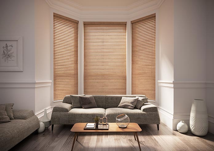 A brown wooden blind in a living room bay window